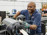 Team member smiling while working on a compression system