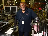 Team member smiling looking at camera on the factory floor