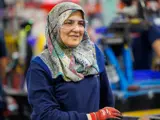 Team member smiling on the factory floor as she contemplates her next task.