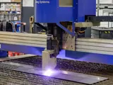 A close-up of a machine cutting through metal with a laser